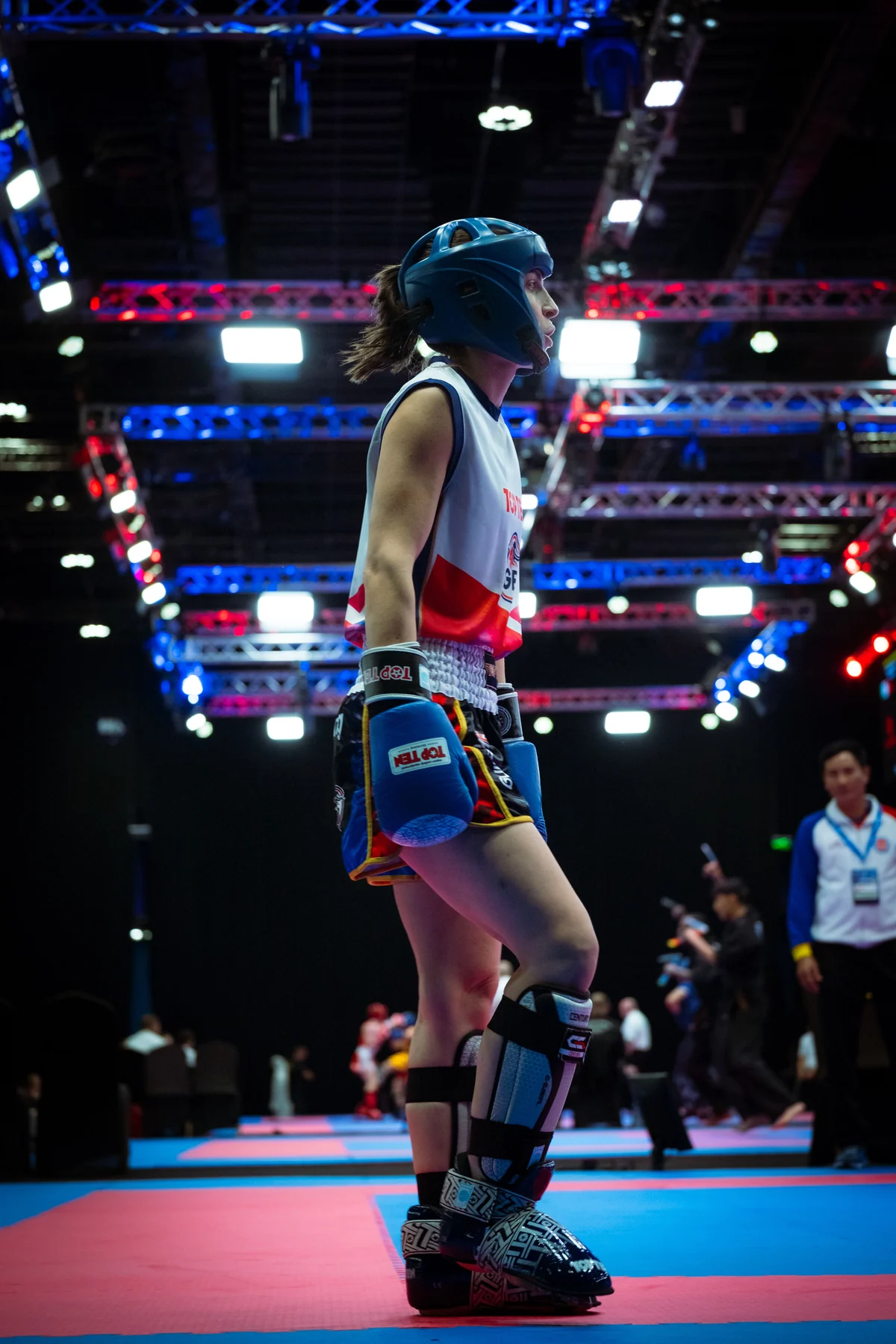 A Kickboxing athlete in Great Britain kit, gloves and shin guards on the competition mats